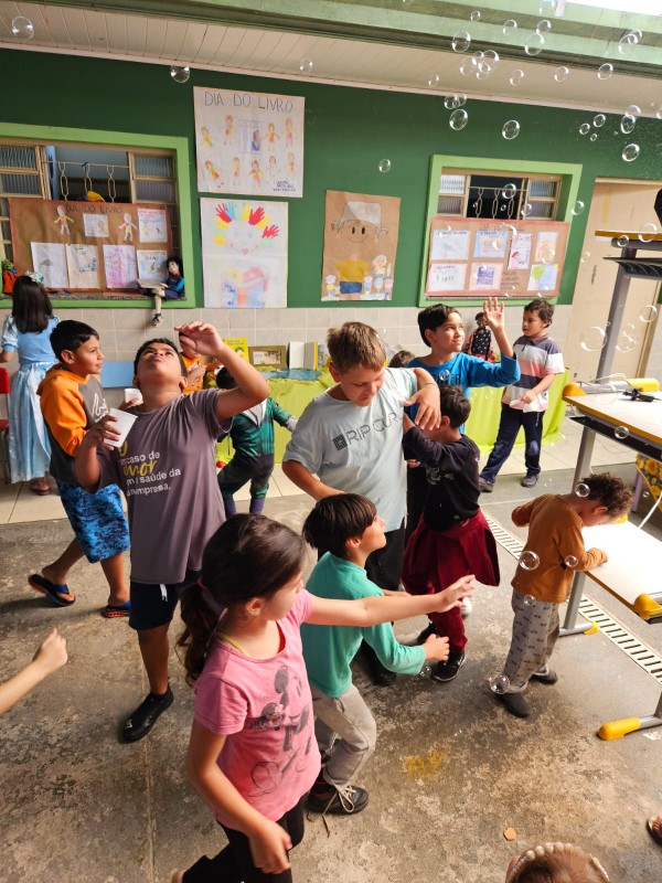 Crianças brincando com bolinhas de sabão na ACRICA